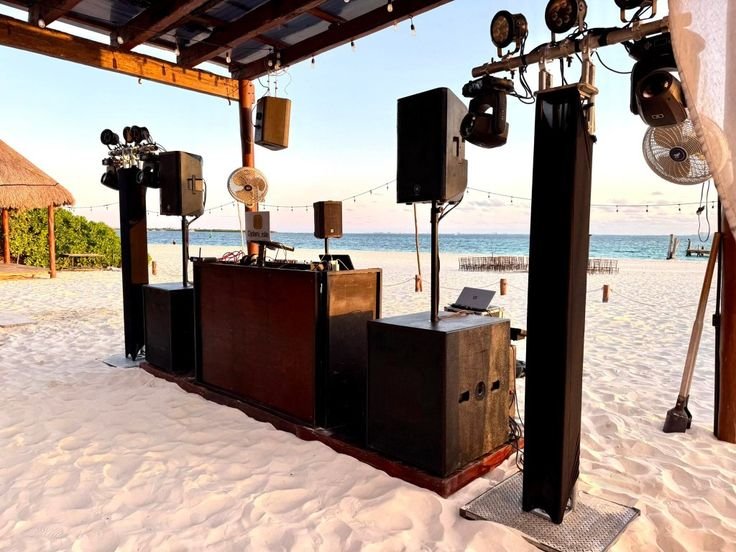 Setup de DJ y sonido en la playa al atardecer
